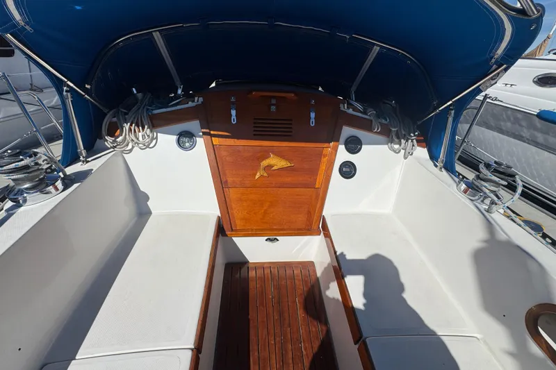 Cockpit of 1985 Catalina 38 sailboat with wooden hatch and blue canopy.
