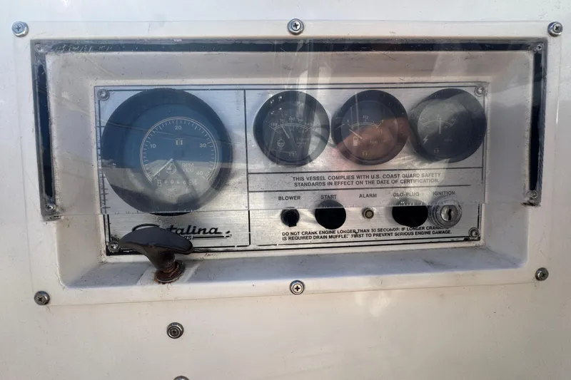 Control panel of a 1985 Catalina 38 sailboat with gauges and ignition switch.