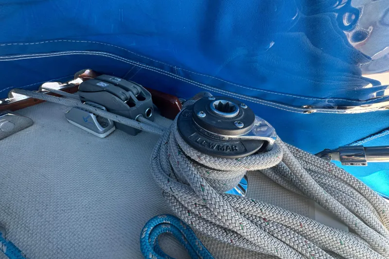 Rope and winch on 1985 Catalina 38 sailboat deck with blue cover.