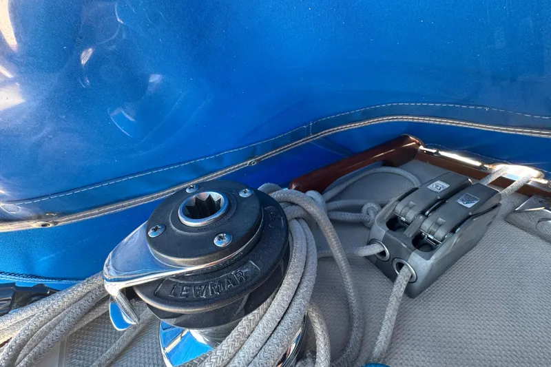 Winch and ropes on a 1985 Catalina 38 sailboat with blue canvas cover.