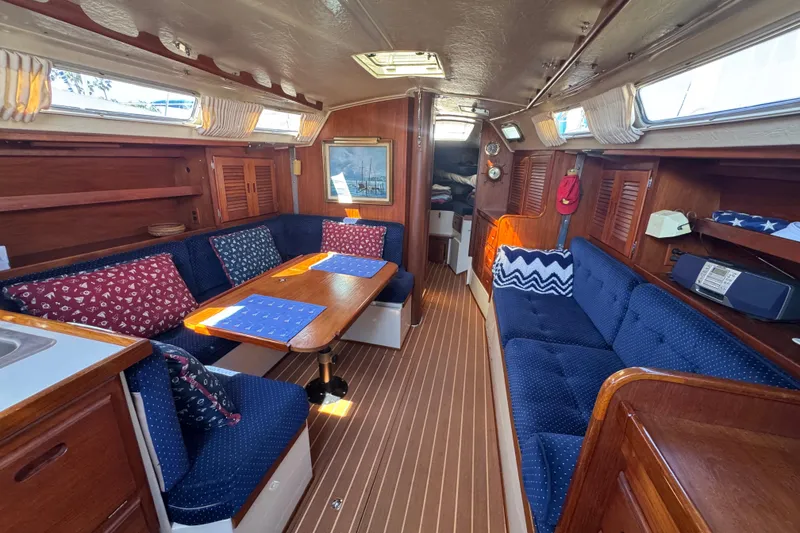 Interior of 1985 Catalina 38 sailboat with cozy seating and wooden finishes.