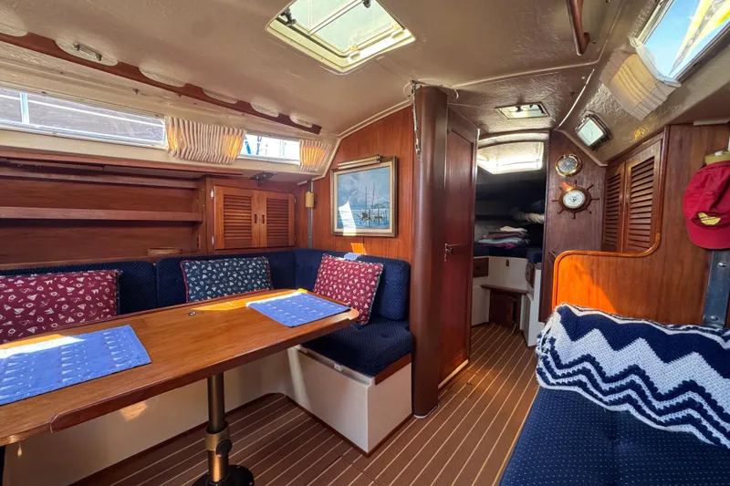 Interior of 1985 Catalina 38 sailboat with cozy seating and wooden finishes.