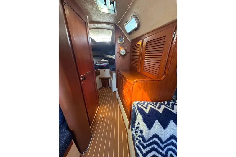 Interior of 1985 Catalina 38 sailboat with wooden cabinetry and nautical decor.