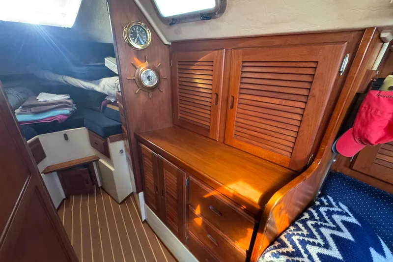 Interior of 1985 Catalina 38 sailboat with wooden cabinetry and cozy sleeping area.