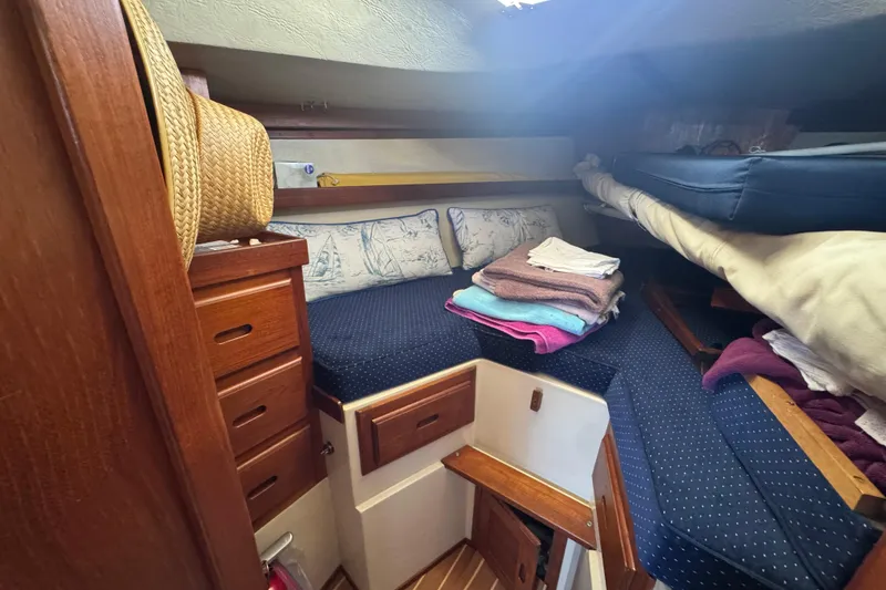 Cozy cabin interior of 1985 Catalina 38 sailboat with storage and bedding.