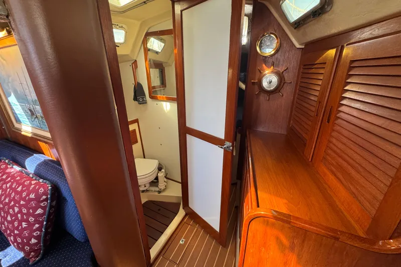 Interior of 1985 Catalina 38 sailboat featuring wooden cabinetry and compact bathroom.