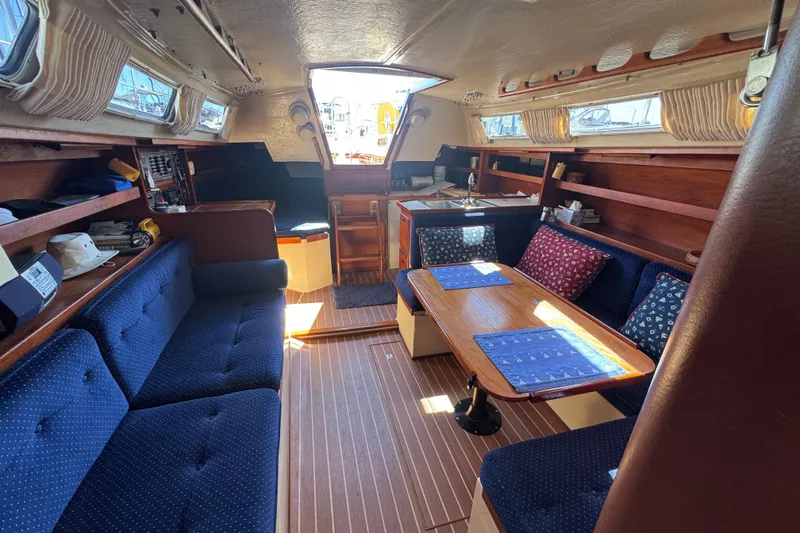 Interior of a 1985 Catalina 38 sailboat with cozy seating and wooden finishes.