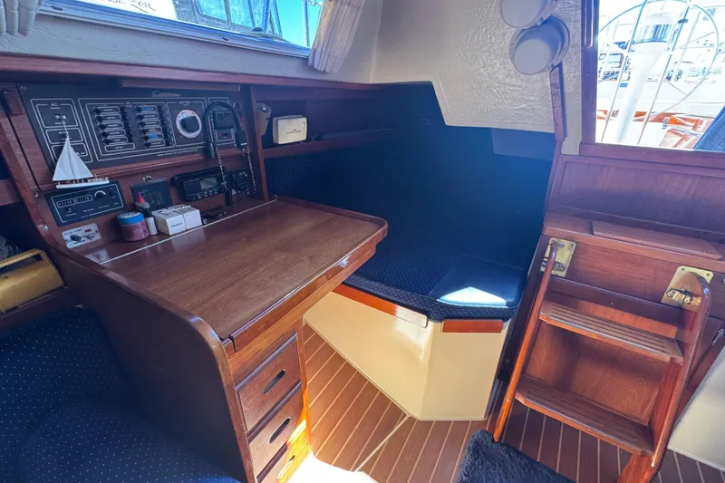 1985 Catalina 38 sailboat interior with navigation station and cozy seating area.