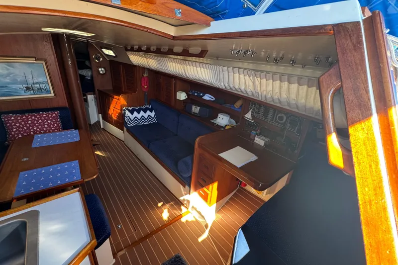 Interior of a 1985 Catalina 38 sailboat with cozy seating and wooden finishes.