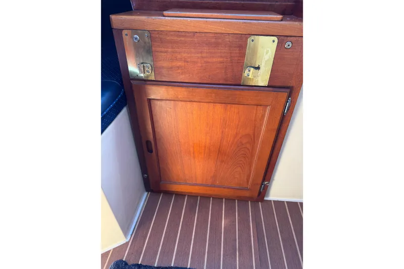Wooden cabinet door on 1985 Catalina 38 sailboat interior with brass hardware.