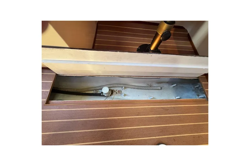 Open hatch on 1985 Catalina 38 sailboat, revealing interior compartment and hose.