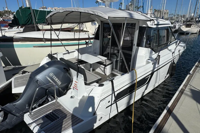 2020 Jeanneau NC 795 boat docked with Yamaha outboard motor, marina background.