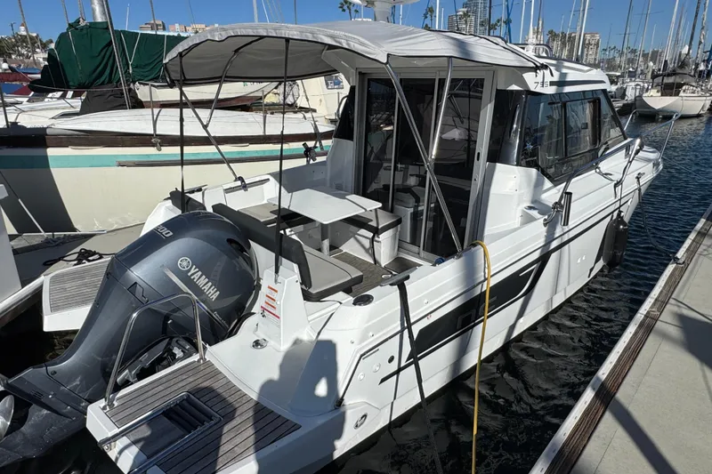 2020 Jeanneau NC 795 boat docked, featuring Yamaha outboard motor and covered seating area.