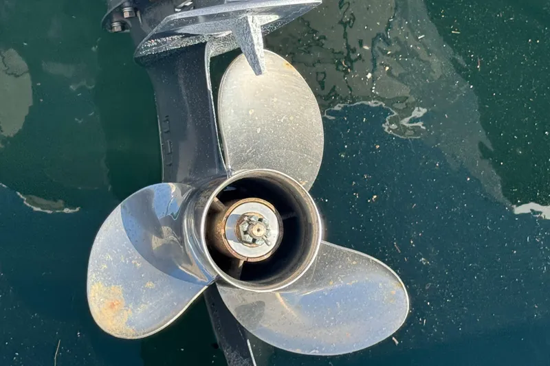 Propeller of a 2020 Jeanneau NC 795 boat in water, showing metallic blades.