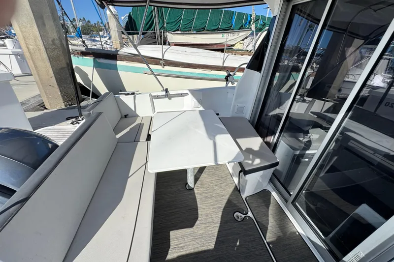 2020 Jeanneau NC 795 boat cockpit with seating and table, docked at marina.