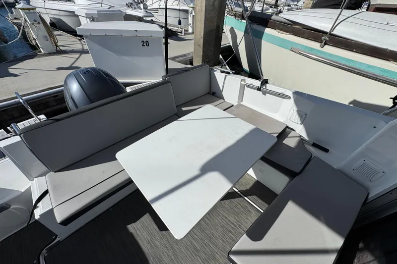 2020 Jeanneau NC 795 boat interior with seating and table in marina setting.