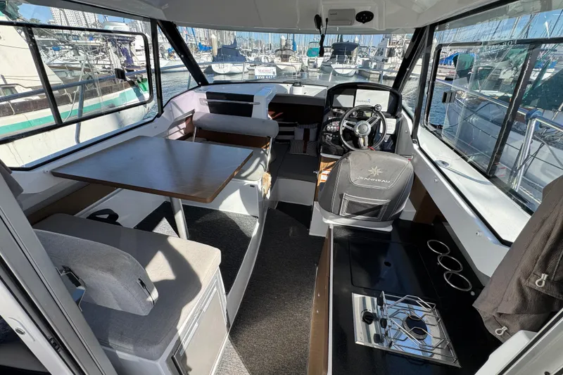 Interior of 2020 Jeanneau NC 795 boat with seating, table, and steering area.