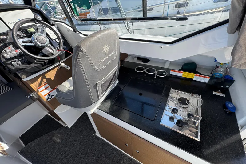 Interior of 2020 Jeanneau NC 795 boat with steering wheel and kitchenette.