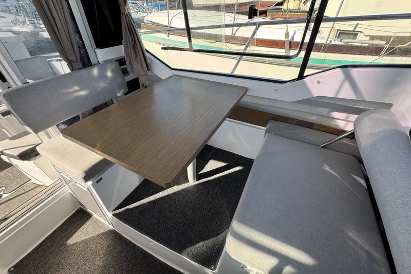 Interior of a 2020 Jeanneau NC 795 boat with a dining table and seating.