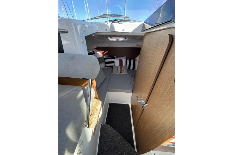 Interior of 2020 Jeanneau NC 795 boat with cozy seating and cushions.