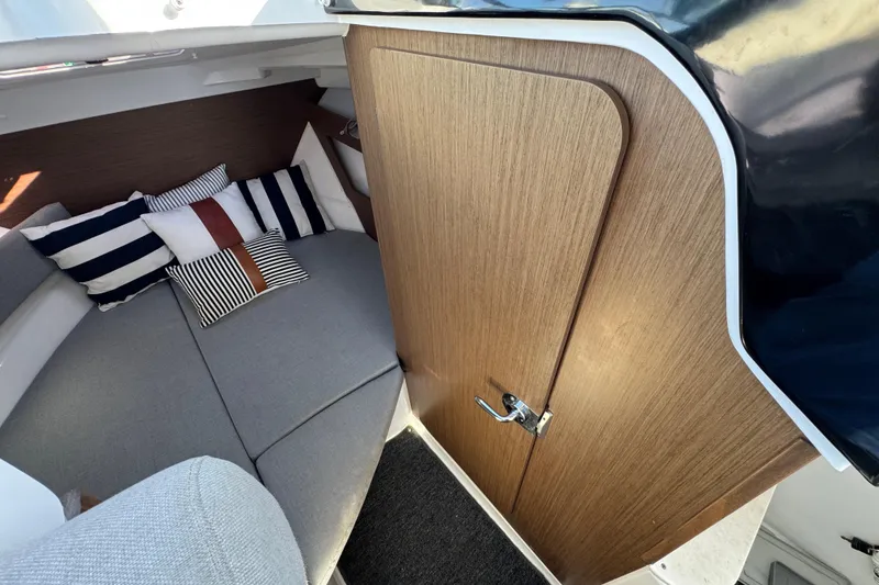 Interior of 2020 Jeanneau NC 795 boat with cozy seating and striped cushions.