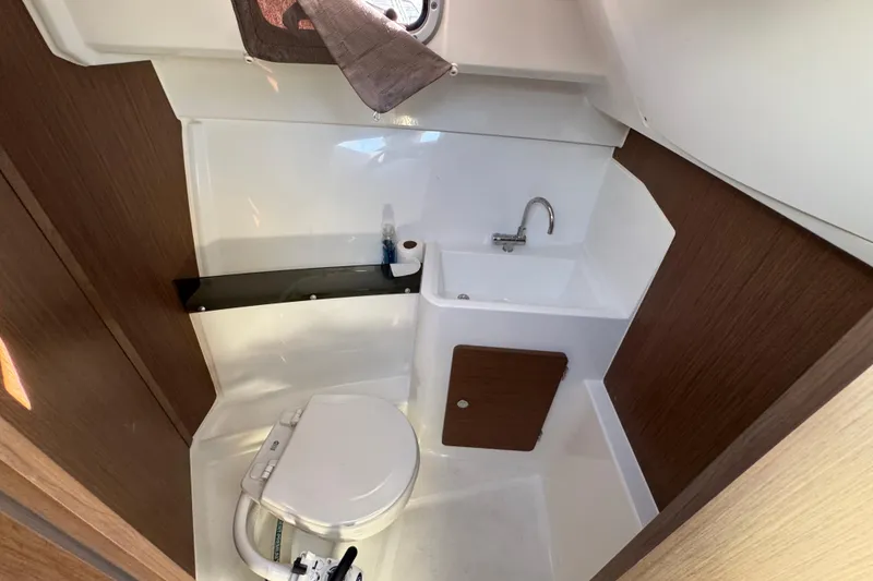Compact bathroom in 2020 Jeanneau NC 795 boat with toilet and sink.
