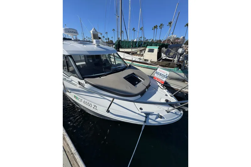 2020 Jeanneau NC 795 boat docked, for sale sign visible, sunny marina setting.