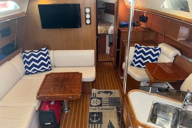Interior of 2016 Catalina 385 sailboat with cozy seating and nautical decor.