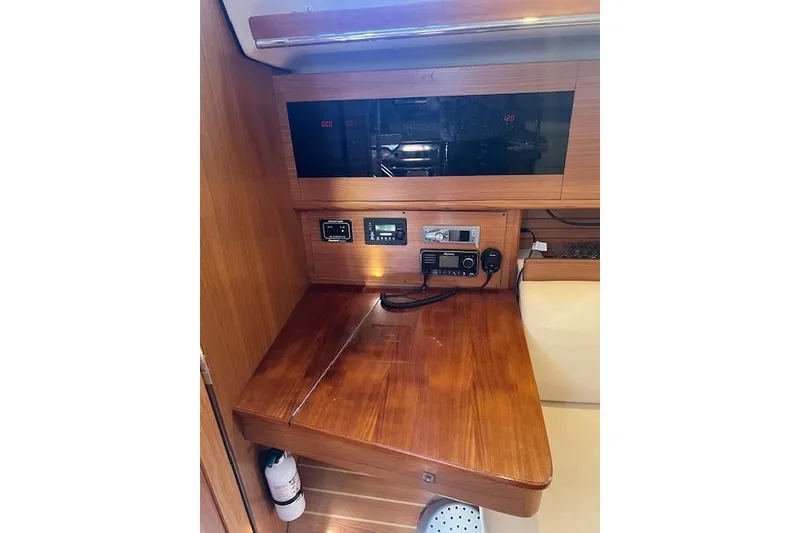 Navigation station in 2016 Catalina 385 sailboat with communication equipment and wooden finish.