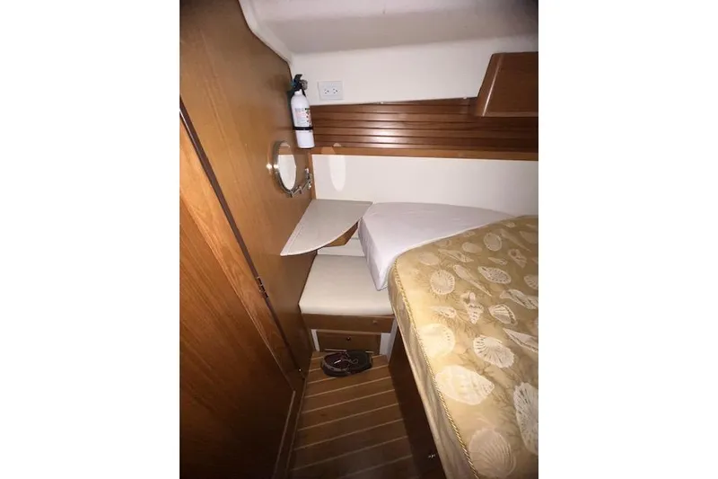 Cozy cabin interior of 2016 Catalina 385 sailboat with wooden accents and bedding.