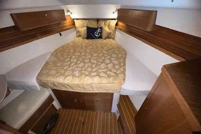 Cozy cabin interior of 2016 Catalina 385 sailboat with wood accents and comfortable bedding.