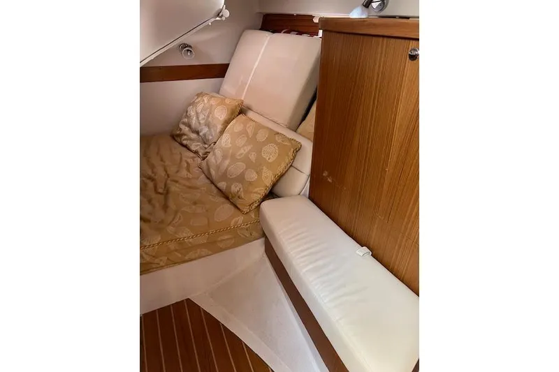 Cozy cabin interior of 2016 Catalina 385 sailboat with cushions and wooden cabinetry.