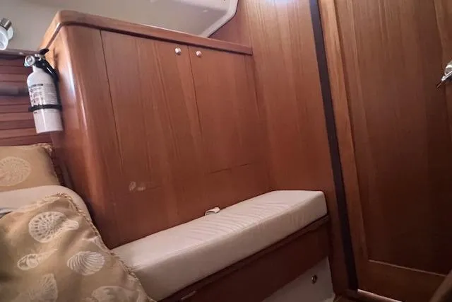 Interior of 2016 Catalina 385 sailboat with wooden cabinetry and cushioned seating.