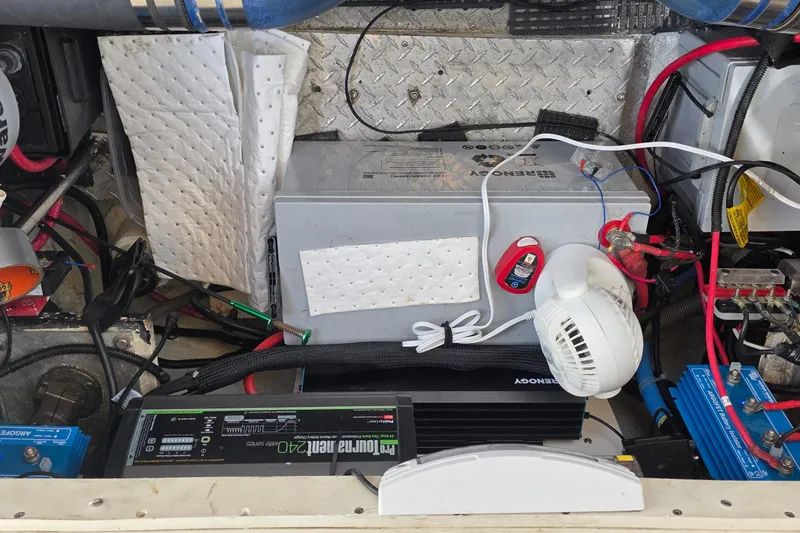 Engine compartment of a 2001 Cruisers Yachts 340 Express with battery and wiring setup.