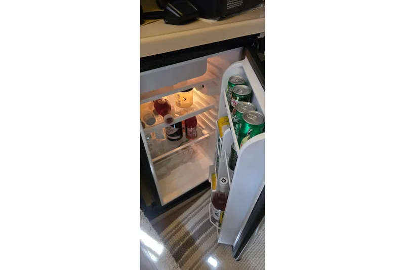 Mini fridge stocked with beverages inside a 2001 Cruisers Yachts 340 Express.