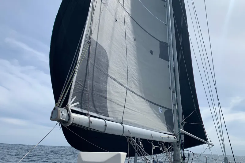 Sailing on a 1972 Tartan 41 yacht with full sails against a cloudy sky.