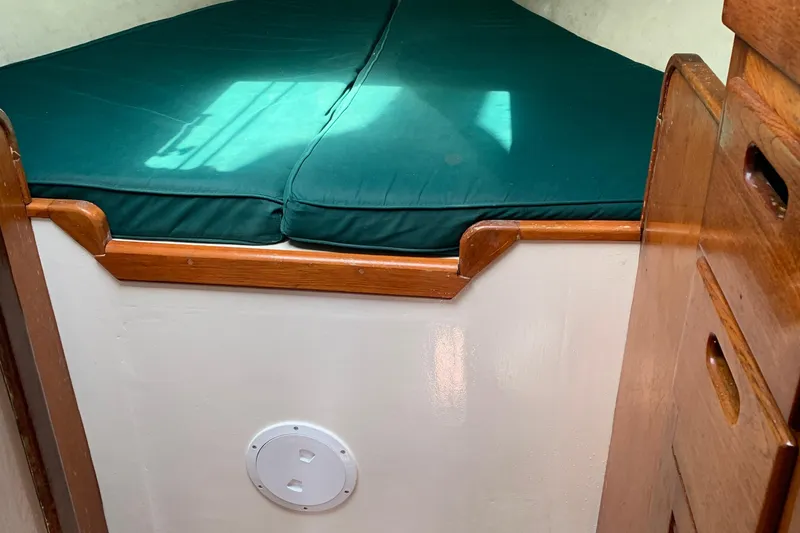 Interior of a 1972 Tartan 41 sailboat with green cushioned berth.