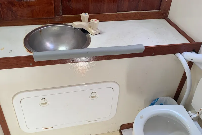 1972 Tartan 41 yacht bathroom with sink and toilet, featuring wood accents.