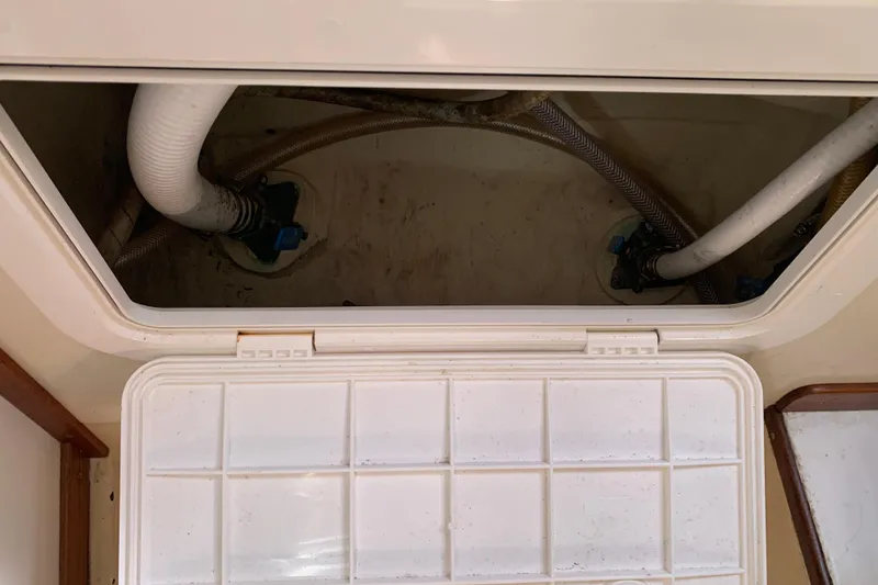 Open hatch with visible plumbing in a 1972 Tartan 41 sailboat.