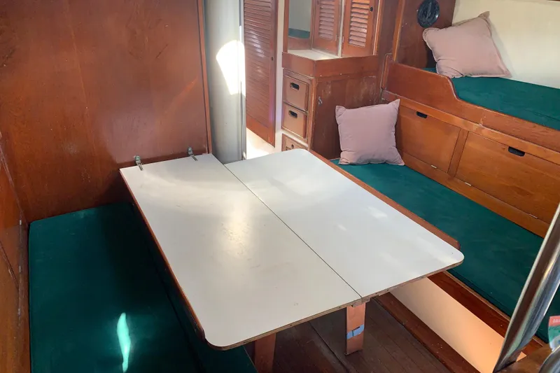 Interior of a 1972 Tartan 41 sailboat with wooden furnishings and green cushions.