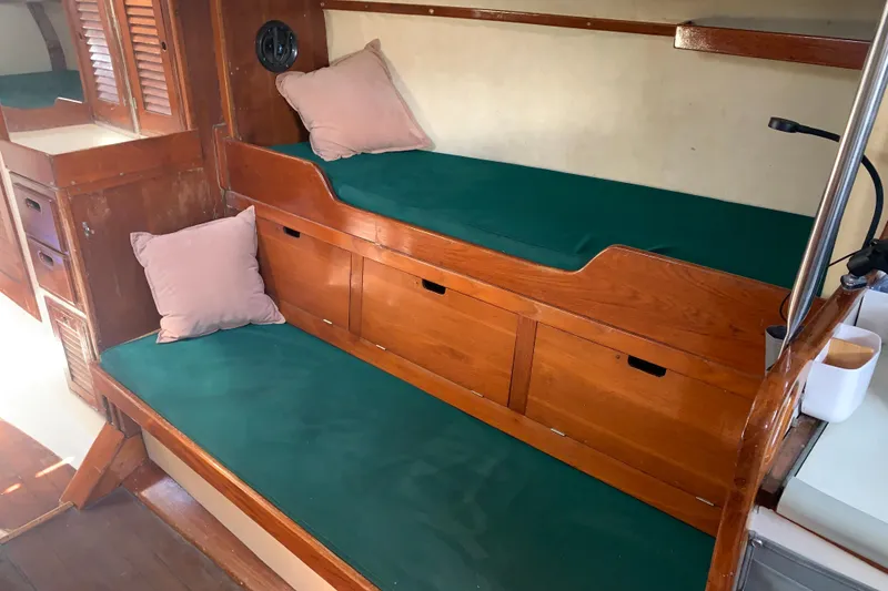 Interior of a 1972 Tartan 41 sailboat with green cushioned seating and wooden cabinetry.