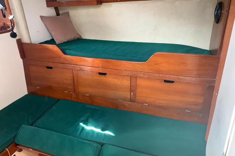 1972 Tartan 41 interior with wooden bunk beds and green cushions.