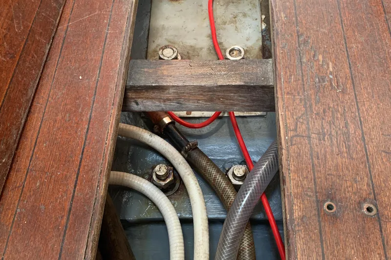 Wooden floorboards and hoses in a 1972 Tartan 41 sailboat interior.
