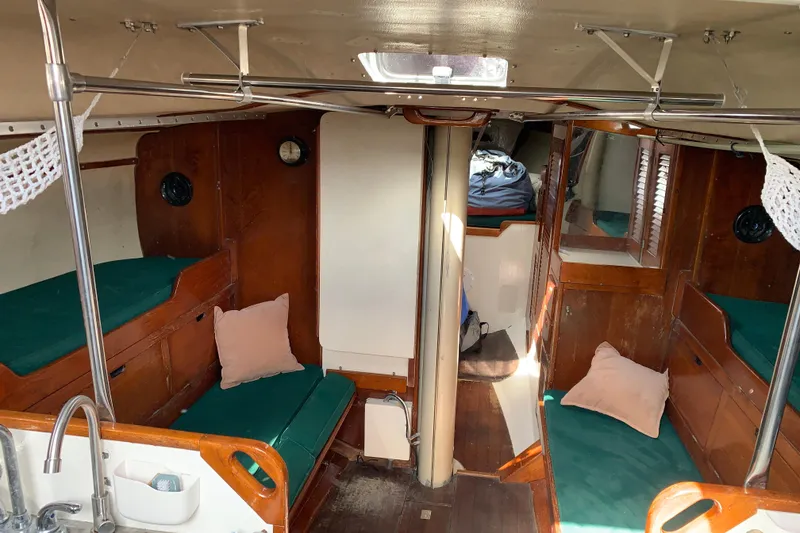 Interior of a 1972 Tartan 41 sailboat with wooden furnishings and green cushions.