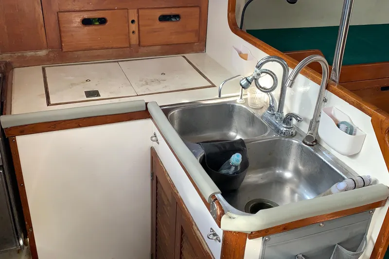 1972 Tartan 41 yacht kitchen with dual sinks and wooden cabinetry.