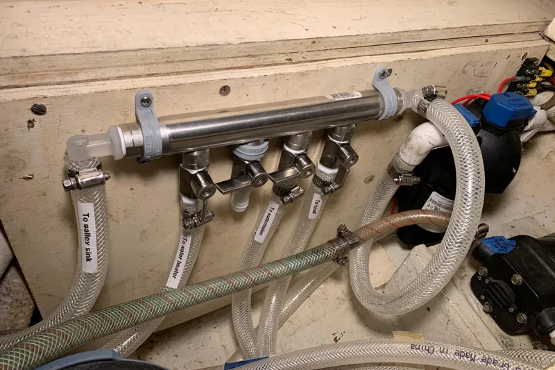 Plumbing system in a 1972 Tartan 41 boat with labeled hoses and valves.