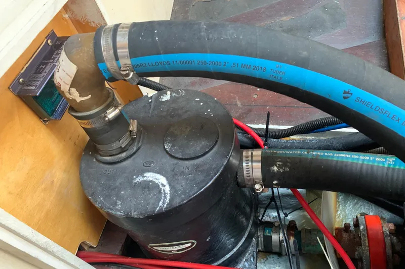 Engine compartment of a 1972 Tartan 41 sailboat with hoses and fittings.