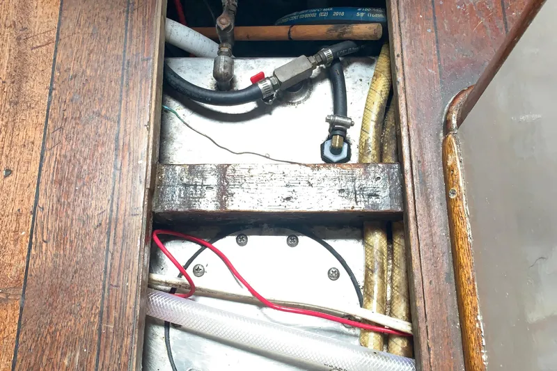 1972 Tartan 41 boat interior showing wooden flooring and visible plumbing components.