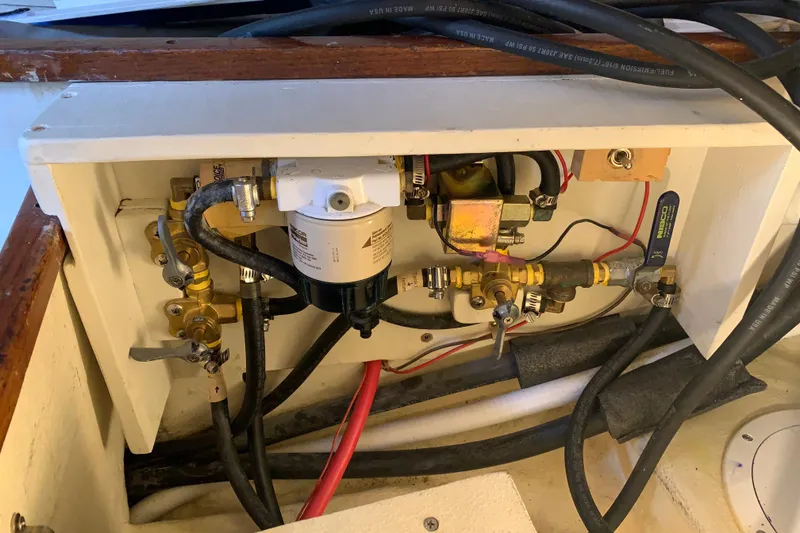 Engine compartment of a 1972 Tartan 41 sailboat, featuring fuel lines and filter system.