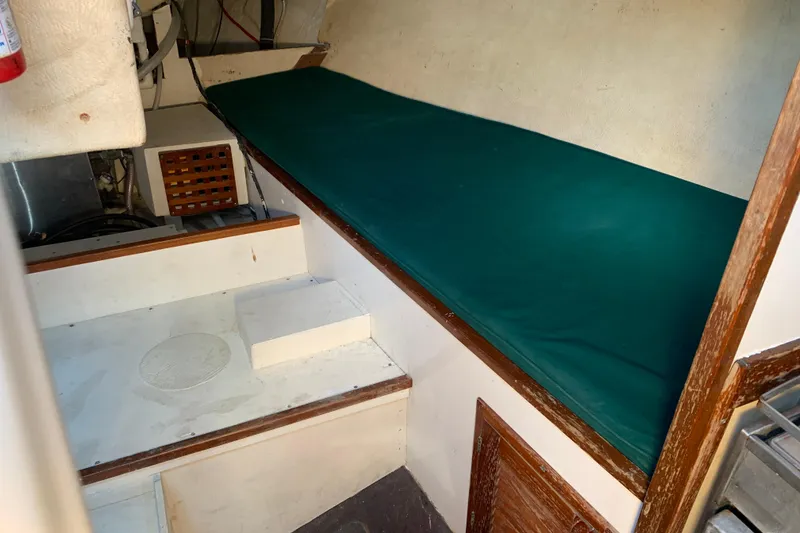 Interior of a 1972 Tartan 41 sailboat with green cushioned berth.